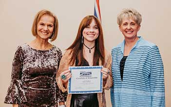 staff holding certificate of scholarship