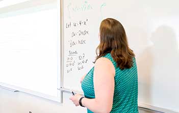 professor at a white board in a classroom